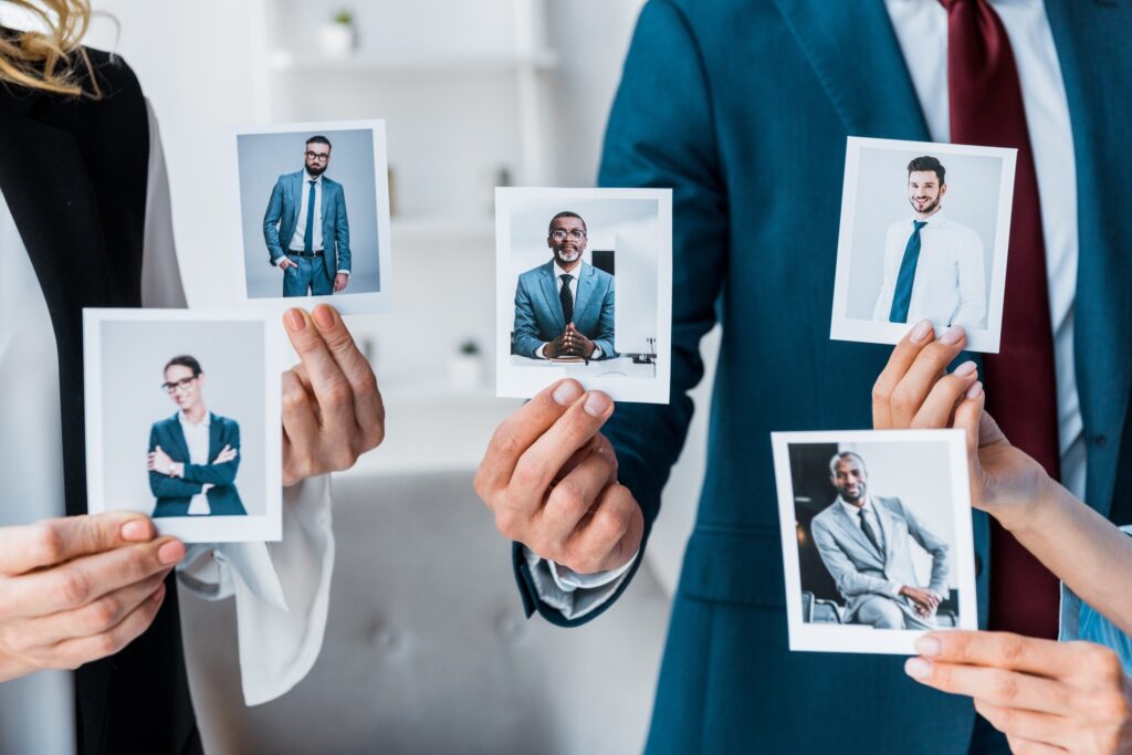 cropped view of recruiters touching photos while standing in office