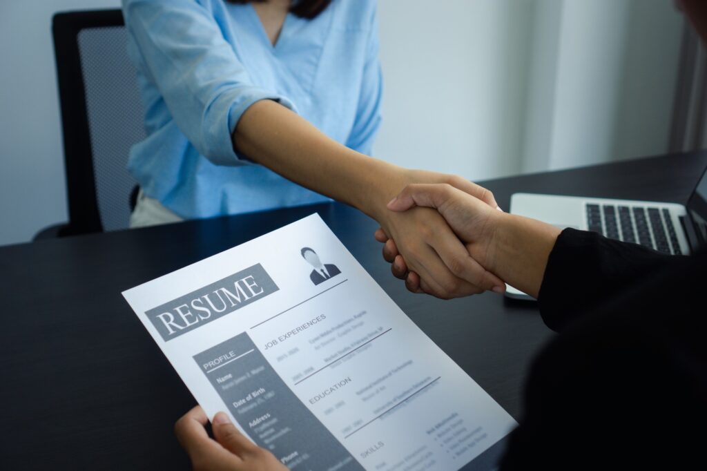Job interviewers are shaking hands to congratulate the shortlisted job applicants for a job at a fin